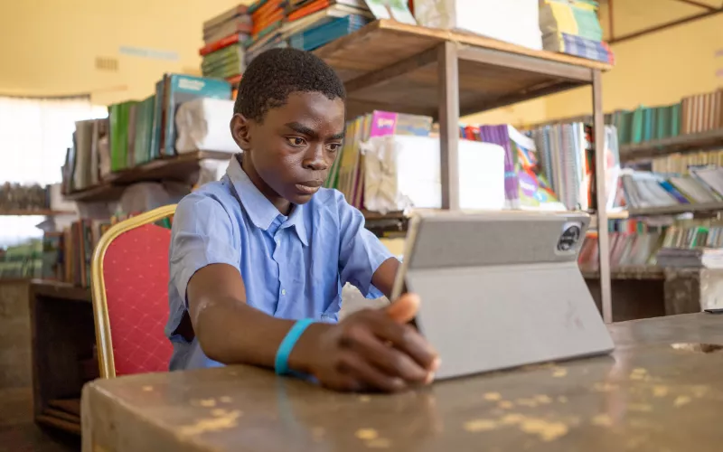 Learener Peter uses a tablet to access his lessons in Zambia