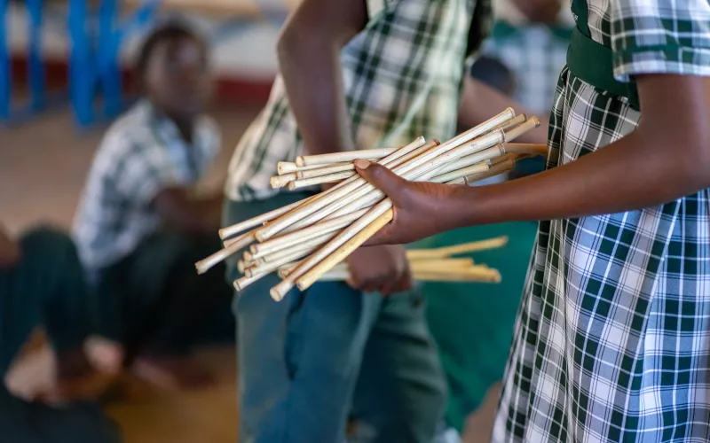 Close up of a learner holding learning materials during a Catch Up lesson. 