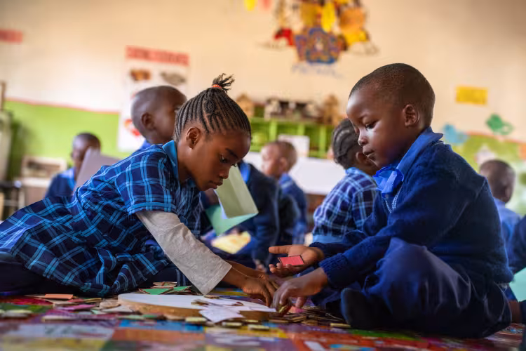 A boy and a girls playing together in the classroom.