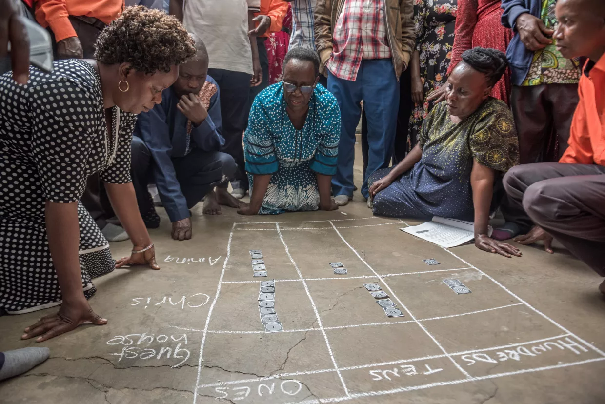 Teachers and mentors share best practices for UCatchUp, pictured drawing with chalk on the floor.