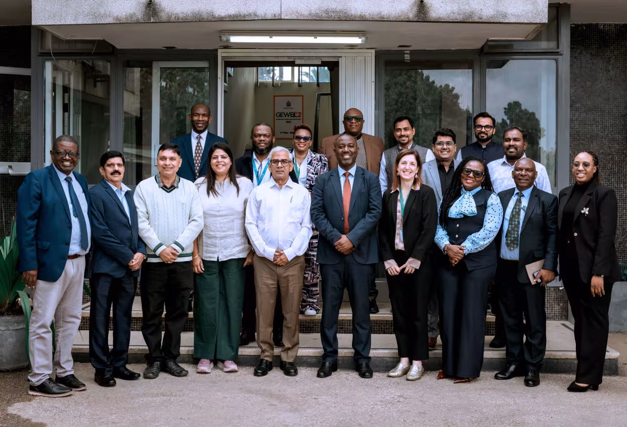 Education leaders from Zambia and India posing for a group picture outside.