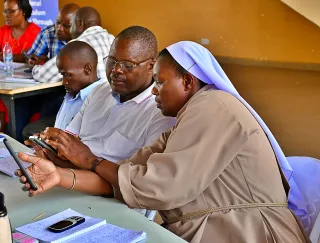 A lady showing a man in glasses a smartphone at a table.