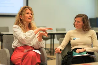 Two women sitting and having an engaged discussion. 