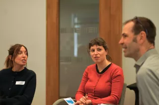 Three people sitting and having an engaging  discussion.