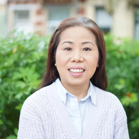 Han is sitting outside, smiling