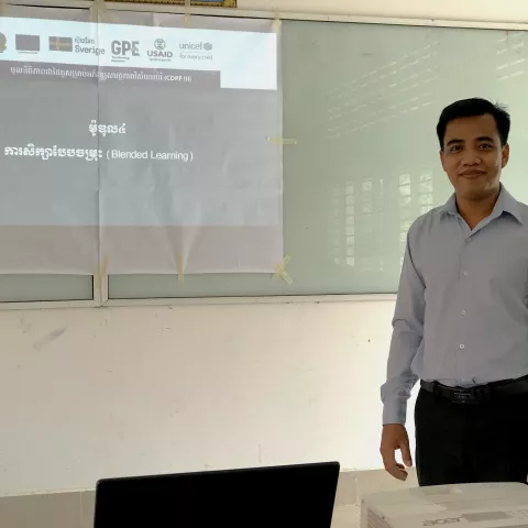 Portrait photo of male Cambodian teacher standing in a classroom