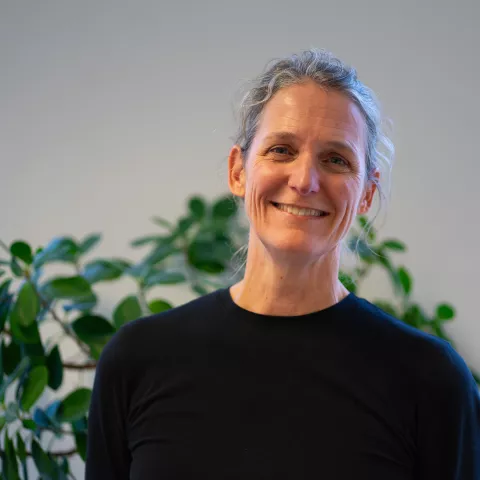 Marije is smiling at the camera, wearing a black sweater.